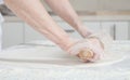 Housewife flattening a dough with a rolling pin