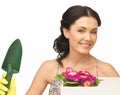 Housewife with flower in box and gardening trowel