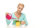 Housewife with flower in pot and watering can