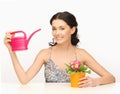 Housewife with flower in pot and watering can Royalty Free Stock Photo