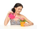 Housewife with flower in pot and watering can