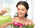 Housewife with flower in pot and watering can Royalty Free Stock Photo