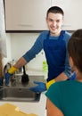 Housewife in green watching plumber's work Royalty Free Stock Photo