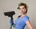 Housewife with hair rollers and gloves happy smiling cheerful holding vacuum cleaner Royalty Free Stock Photo