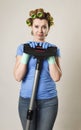 Housewife with hair rollers and gloves happy smiling cheerful holding vacuum cleaner