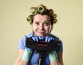 Housewife with hair rollers and gloves happy smiling cheerful holding vacuum cleaner