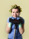 Housewife with hair rollers and gloves happy smiling cheerful holding vacuum cleaner Royalty Free Stock Photo