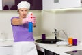 Housewife having fun taking aim with the detergent Royalty Free Stock Photo