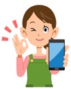 Housewife holding a smartphone and showing a sign of OK