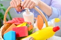 Housewife holds basket with cleaning chemicals.