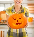 Housewife in kitchen showing big pumpkin Jack-O-Lantern Royalty Free Stock Photo