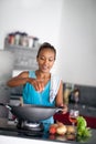 Housewife in kitchen squeezes tomato in meal