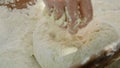 Housewife kneading dough in a wooden bowl