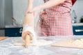Housewife knocks the rolling pin on the table, over the dough lying on the kitchen table. Hands close up. Concept of homemade food Royalty Free Stock Photo