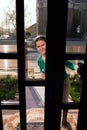 Housewife looking through glass door