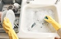 Housewife, maid or cleaner hands washing dishes in the kitchen sink for home hygiene, wearing rubber gloves. Contact us Royalty Free Stock Photo