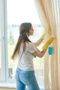 Housewife near a window, cleaning. Royalty Free Stock Photo