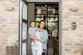 Housewife with newborn baby staying in front of entrance door Royalty Free Stock Photo