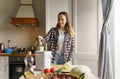 Cheerful white woman composting natural food waste in a bokashi bin. Adult female person using composter to recycle organic