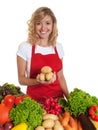 Housewife with red apron and fresh vegetables presenting potatoes Royalty Free Stock Photo