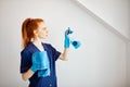 Housewife with red-haired ponytail holds dusting cloth and wiper. Royalty Free Stock Photo