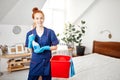 Housewife with red-haired ponytail holds dusting cloth and wiper. Royalty Free Stock Photo