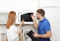 Housewife and repairman near microwave oven Royalty Free Stock Photo