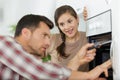 housewife and repairman near microwave oven in kitchen Royalty Free Stock Photo