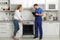 Housewife with repairman near modern oven Royalty Free Stock Photo