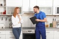 Housewife with repairman near modern oven Royalty Free Stock Photo