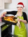 Housewife in Santa hat baking festive capon