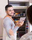 Housewife showing broken refrigerator Royalty Free Stock Photo