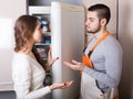 Housewife showing broken refrigerator Royalty Free Stock Photo