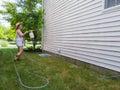 Housewife spraying down the exterior facade