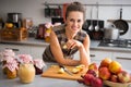 Housewife standing near jars with fruits jam