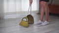 A woman sweeps the floor in an apartment