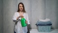 The housewife washes clothes. A young woman pours liquid washing powder. Royalty Free Stock Photo