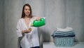 The housewife washes clothes. A young woman pours liquid washing powder. Royalty Free Stock Photo