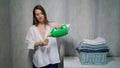 The housewife washes clothes. A young woman pours liquid washing powder. Royalty Free Stock Photo