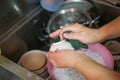 Housewife Washing kitchen ware on the sink hand washing dish or pouring glass with fresh drink water Royalty Free Stock Photo