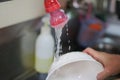 Housewife Washing kitchen ware on the sink hand washing dish or pouring glass with fresh drink water Royalty Free Stock Photo