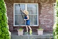 Housewife washing the windows of her house