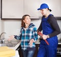 Housewife watching as plumber working Royalty Free Stock Photo