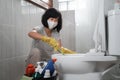 housewife wearing a mask wearing gloves brushing the dirty toilet