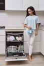 housewife woman standing with towel and using modern dishwasher Royalty Free Stock Photo