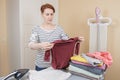 Housewife woman takes apart the washed baby clothes for subsequent ironing
