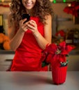 Housewife writing sms in christmas decorated kitchen