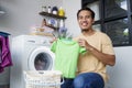 Housework. asian Man loading clothes into washing machine Royalty Free Stock Photo