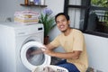 Housework. asian Man loading clothes into washing machine Royalty Free Stock Photo