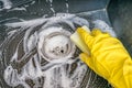 Housework concept. Person is cleaning granite sink in kitchen with sponge